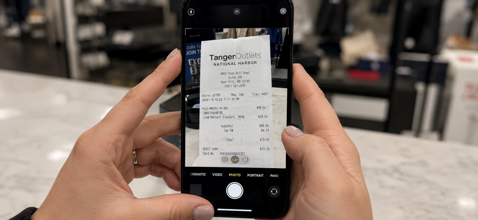 Pessoa fotografando recibo de compra com o celular na loja em Orlando